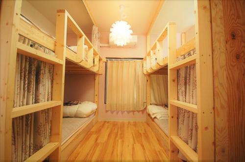a room with bunk beds and a chandelier at 西条ゲストハウス八反 in Higashihiroshima