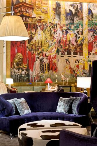 a living room with purple couches and a large painting at Wanda Vista Beijing in Beijing