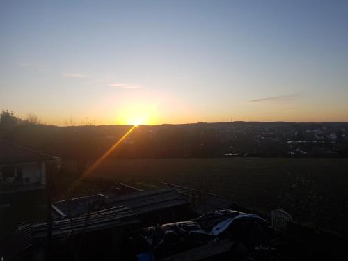 a sunset over a field with the sun setting at 50 Quadratmeter abgeschlossene Wohnung mit Panoramablick in Pfaffenhofen an der Ilm