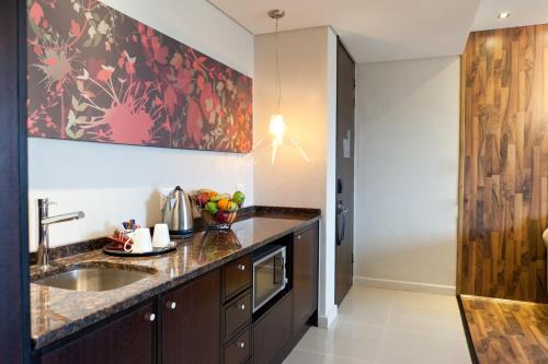 uma cozinha com um lavatório e um balcão em Colosseum Luxury Hotel na Cidade do Cabo