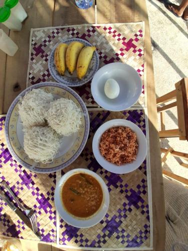 ein Tisch mit Tellern und Schüsseln mit Essen darauf in der Unterkunft The Sky Tents in Kandy