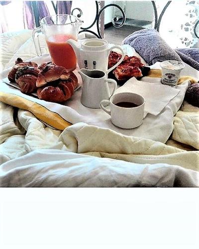 a tray of donuts and cups of coffee on a bed at Only for two Giumbabulla in Ragusa