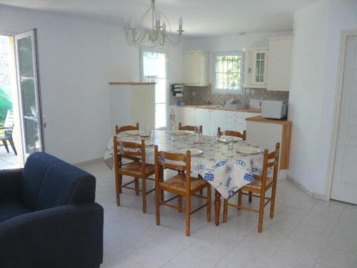 une cuisine avec une table avec des chaises et une salle à manger dans l'établissement mamaisonaoleron 3ch-6pers calme terrain clos OLERON, à Grand-Village-Plage