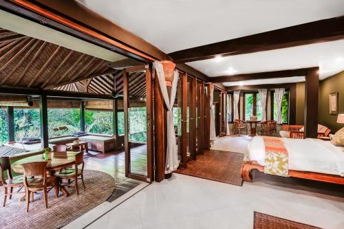 a bedroom with a bed and a table and chairs at Villa Beji Indah in Ubud