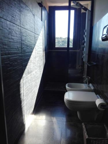 a bathroom with a toilet and a sink and a window at Only for two Giumbabulla in Ragusa