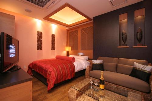a hotel room with a bed and a couch at HOTEL W-PREMIUM -W GROUP HOTELS and RESORTS- in Koshigaya
