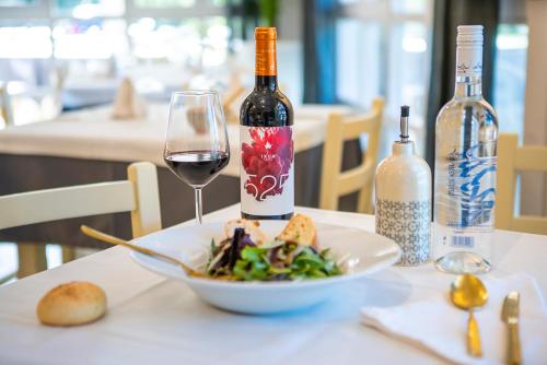 a table with a plate of food and a glass of wine at IXUA Hotela in Éibar