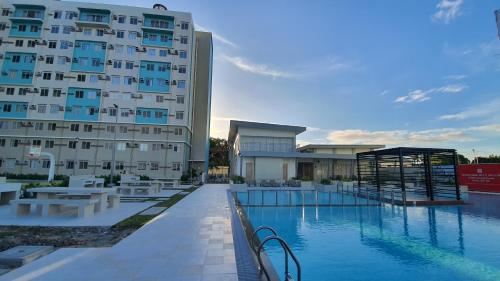 un hotel con piscina frente a un edificio en JAS Marina Spatial en Dumaguete