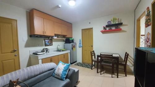 a kitchen and a living room with a couch and a table at JAS Marina Spatial in Dumaguete