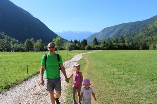 a man and two children walking down a dirt road at Apartments & Hostel Bohinj in Bohinj