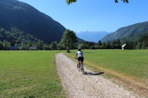 a person riding a bike down a dirt road at Apartments & Hostel Bohinj in Bohinj