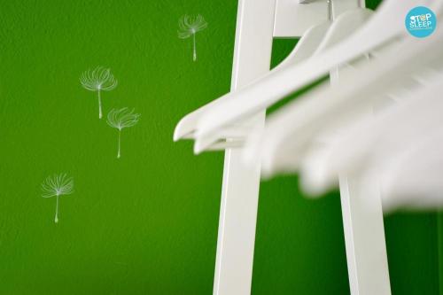 a green wall with white drawings of plants on it at Stop & Sleep Udine Fronte Ospedale Civile in Udine