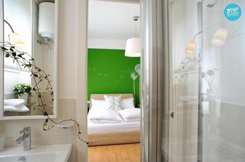 a bathroom with a green accent wall and a bed at Stop & Sleep Udine Fronte Ospedale Civile in Udine
