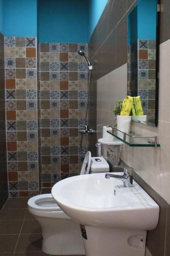 a bathroom with a sink and a toilet and a mirror at Selena Dalat Homestay in Da Lat