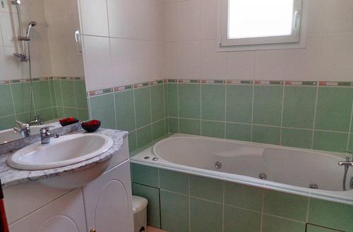 a bathroom with a sink and a bath tub at Gîte des Moulins - Val d'Azun Pyrénées in Arcizans-Dessus