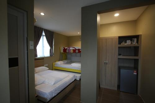 a small bedroom with two beds and a window at Shamrock Greenhill in Ipoh