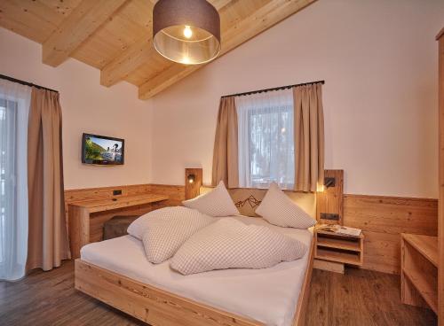 ein Schlafzimmer mit einem Bett mit weißen Kissen in der Unterkunft Apart Montagna in Gries