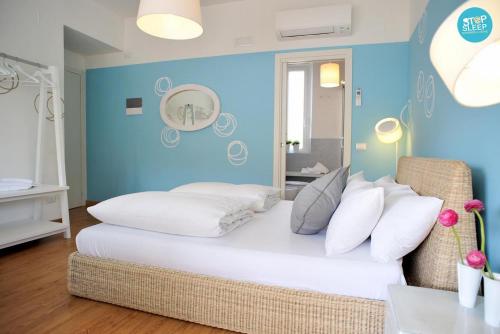 a room with a large white bed with blue walls at Stop & Sleep Udine Fronte Ospedale Civile in Udine