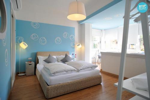 1 dormitorio con 1 cama con pared azul en Stop & Sleep Udine Fronte Ospedale Civile en Udine