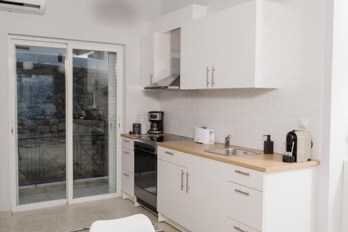 a white kitchen with a sink and a stove at nelion 01 - a DREAM apartment with amazing view in Aígio