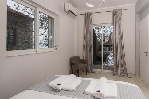 a white bedroom with a bed and a window at nelion 01 - a DREAM apartment with amazing view in Aigio