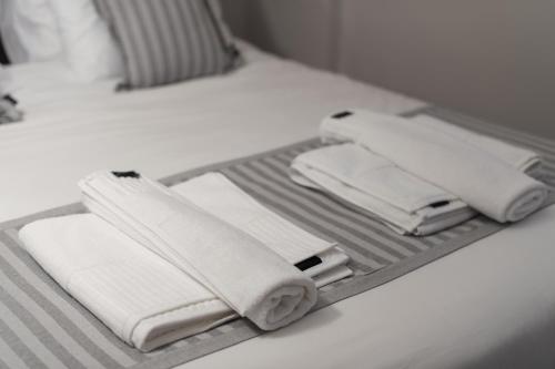 a tray with white towels on a bed at nelion 01 - a DREAM apartment with amazing view in Aigio