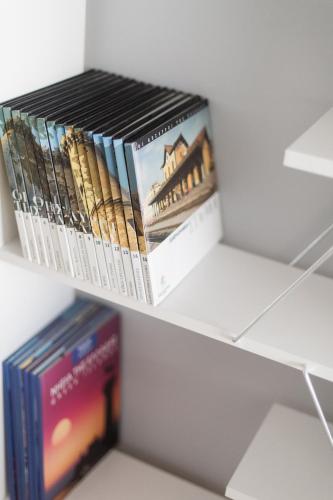 a stack of books sitting on a shelf at nelion 01 - a DREAM apartment with amazing view in Aígio