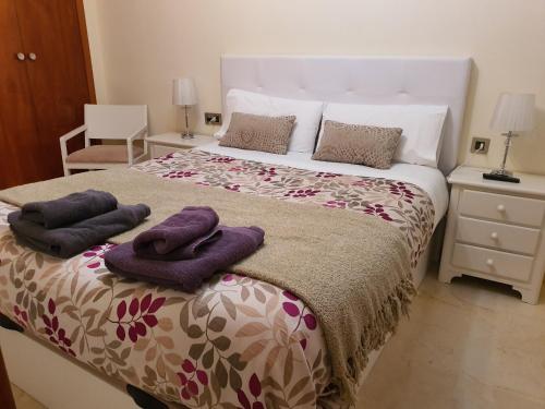 Un dormitorio con una cama con toallas moradas. en Jaen Home, en Jaén