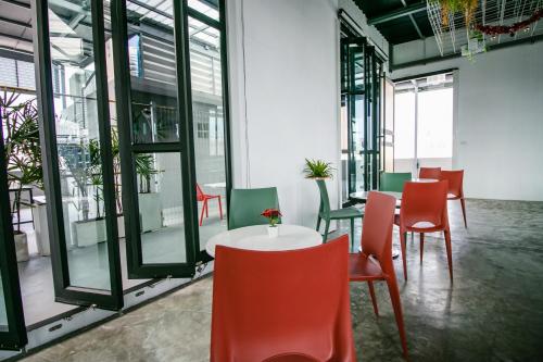 a room with a table and chairs and windows at Fine Bed Hotel in Nonthaburi