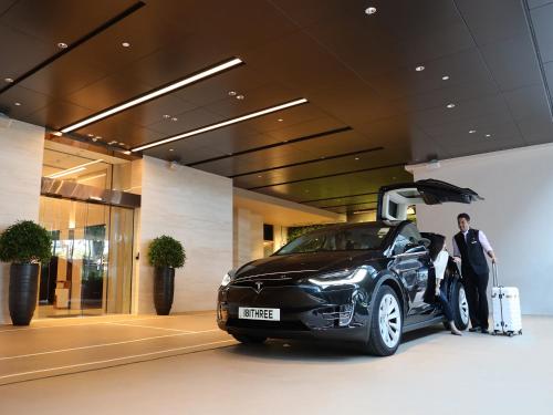 a man standing next to a car with his luggage at Oasis Aurum 181 Hotel in Hong Kong