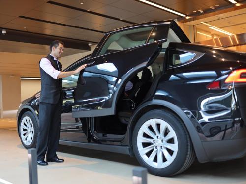 a man is standing next to a car at Oasis Aurum 181 Hotel in Hong Kong