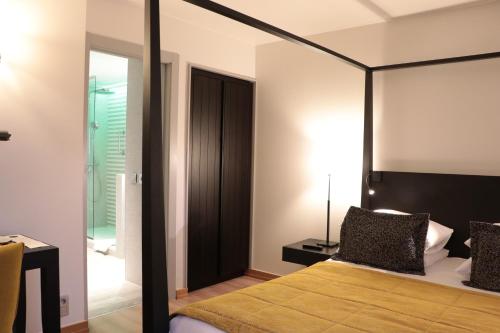 a bedroom with a bed with a black frame and a mirror at Martin's Château Du Lac in Genval