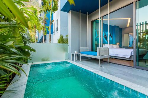 a villa with a swimming pool next to a bedroom at BlueSotel SMART Krabi Aonang Beach - Adults only in Ao Nang Beach