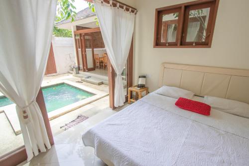 a bedroom with a bed and a swimming pool at Bali Kembali Hotel in Sanur