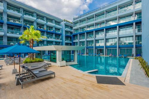 a large building with a swimming pool in front of it at BlueSotel SMART Krabi Aonang Beach - Adults only in Ao Nang Beach
