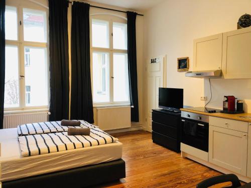 a room with a bed and a kitchen with windows at Modernes Apartment am Viktoria Luise Platz in Berlin