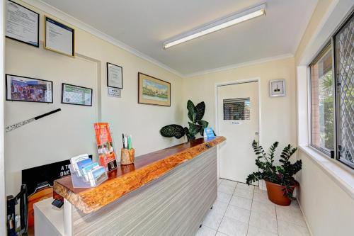 a kitchen with a white counter top and a large window at Moore Park Beach Motel in North Coast