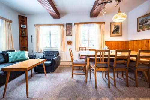 ein Wohnzimmer mit Tisch und Stühlen in der Unterkunft Hájenka Harrachov in Harrachov