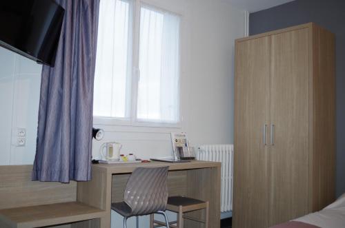 a bedroom with a desk with two chairs and a window at The Originals City, Hôtel Le Savoy, Caen in Caen