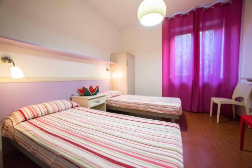 two beds in a room with purple curtains at Villa Rosanna in Capoliveri