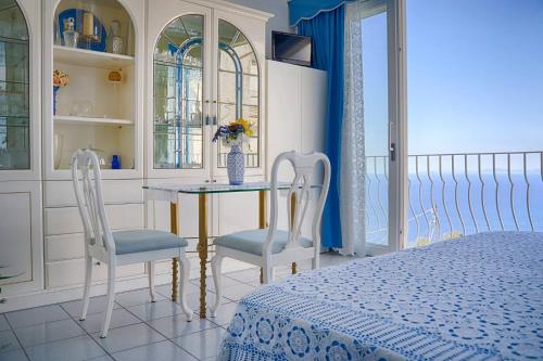 a bedroom with a table and two chairs and a bed at B&B Il Bacio di Capri in Anacapri