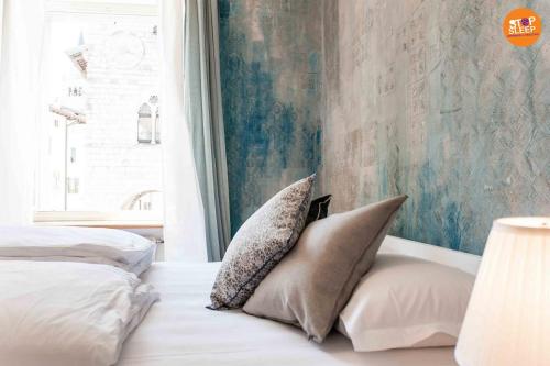 a bedroom with two pillows on a bed with a window at Stop & Sleep Venzone in Venzone