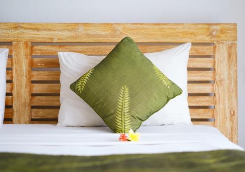 a green pillow sitting on top of a bed at d'Sawah Amed Homestay & Warung in Amed