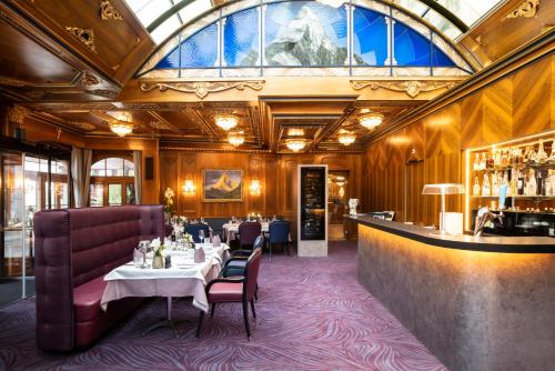 采爾馬特的住宿－采爾馬特霍夫大酒店，餐厅设有桌椅和玻璃天花板