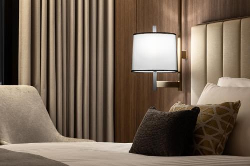 a bedroom with a bed with a lamp and a chair at Mitsui Garden Hotel Roppongi Tokyo Premier in Tokyo