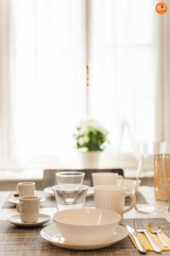 a table with white cups and saucers on it at Stop & Sleep Venzone in Venzone