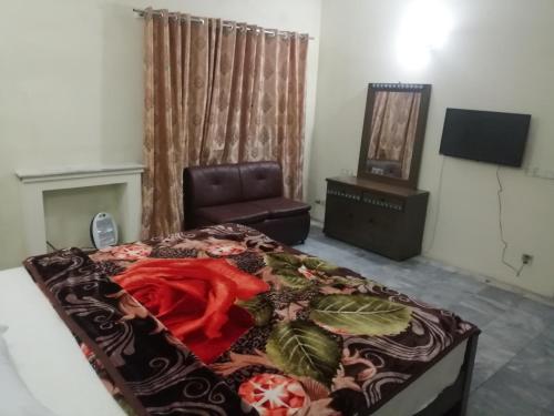 Star Hotel Lahore في لاهور: غرفة نوم بسرير وكرسي في غرفة