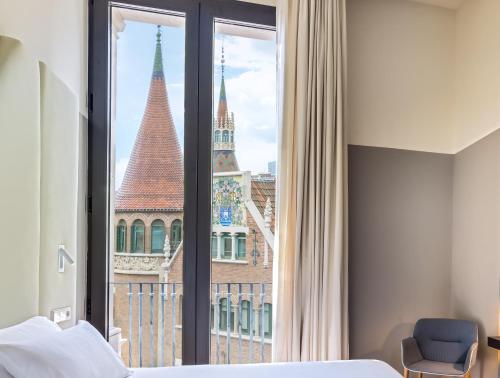 a bedroom with a bed and a large window at Occidental Diagonal 414 in Barcelona