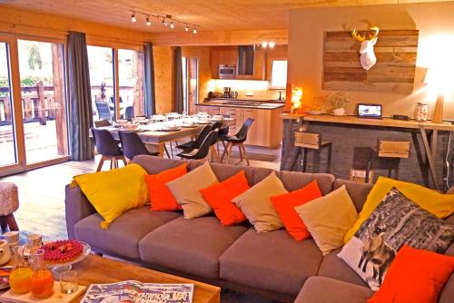 - un salon avec un canapé et des oreillers colorés dans l'établissement Chalet KAWA, à Les Allues