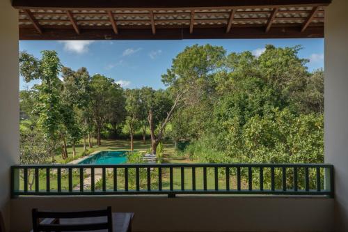 a view from a balcony of a pool and trees at Sevanagama in Habarana